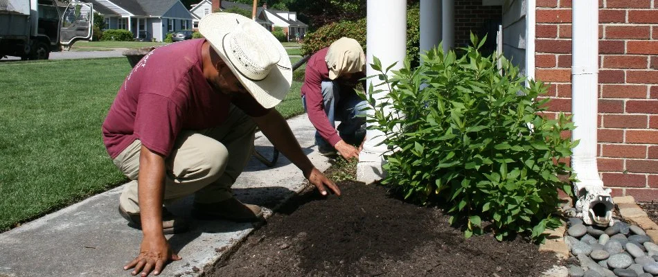 Workers installing mulch in a landscape bed on a property in Memphis, TN.