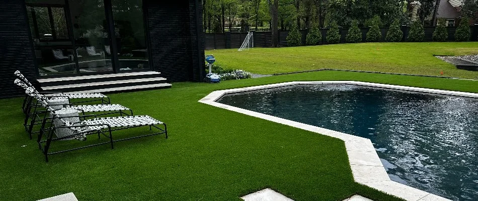 An outdoor space in Memphis, TN, with synthetic grass, outdoor steps, and a pool.